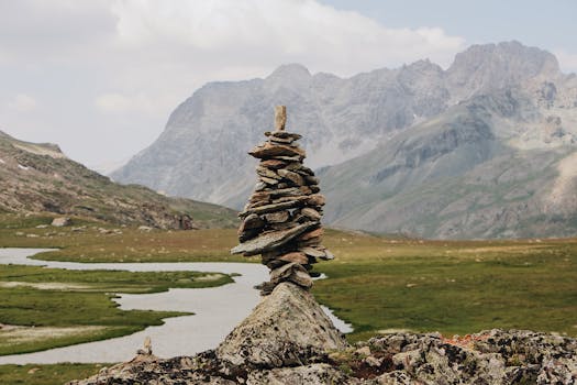 雄伟的山脉和蜿蜒的溪流前，石堆呈现出一片宁静的景象