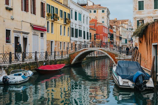 Explore Venice's picturesque canal scene with vibrant buildings and moored boats.