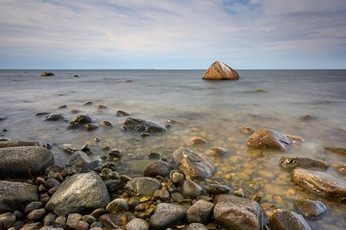 Free Serene beach scene with large rocks and calm sea, perfect for nature lovers. Stock Photo