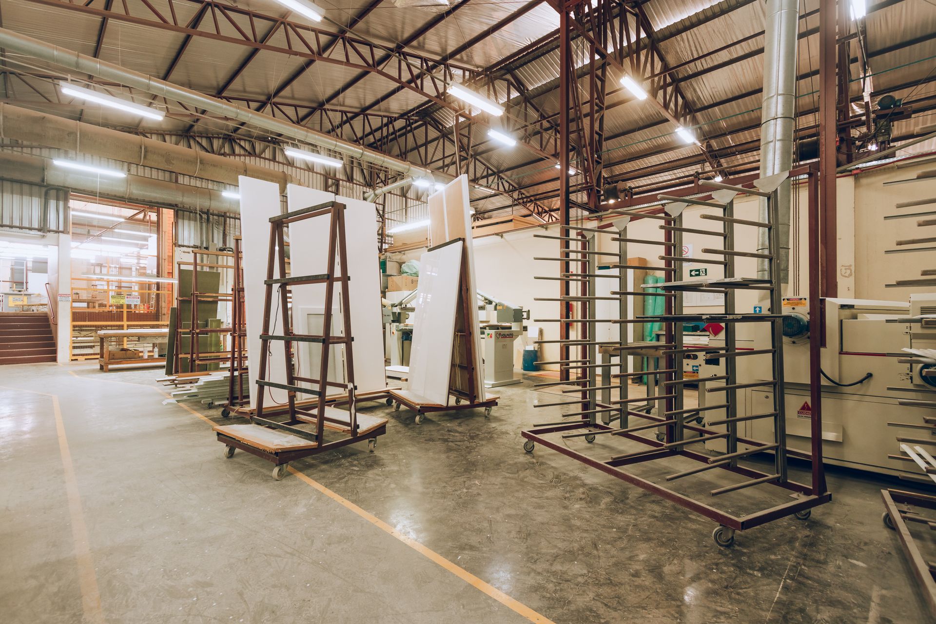 A large, well-lit industrial factory interior showcasing machinery and storage solutions.