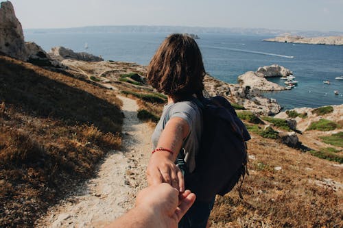 Photo of Couple Holding Hands While Standing Outdoors