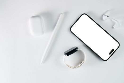 Top view of smartphone and tech accessories, emphasizing minimalist design and wireless connection.