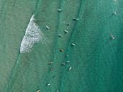 冲浪者在阳光明媚的日子里享受碧绿大海的航拍照片