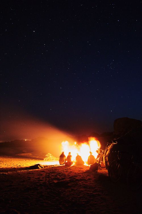 Veillée au feu de camp en camping sous les étoiles Groupe de personnes réunis autour d'un feu de camp sous un ciel étoilé