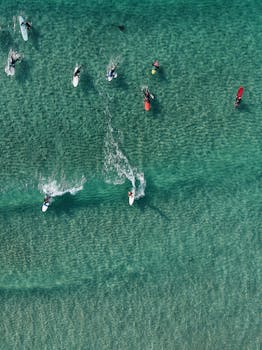 这张高角度航拍照片捕捉到了冲浪者在晶莹剔透海浪上的动作与夏日氛围