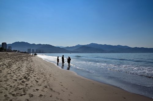 Free Silhouette of people walking along Puerto Vallarta beach at sunset. Stock Photo