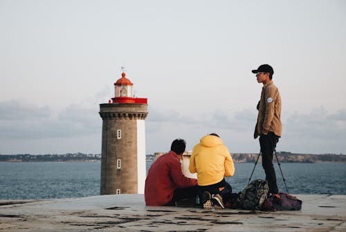 Free Young Men On The Concrete Pavement  By The Sea Close To The Lighthouse Stock Photo