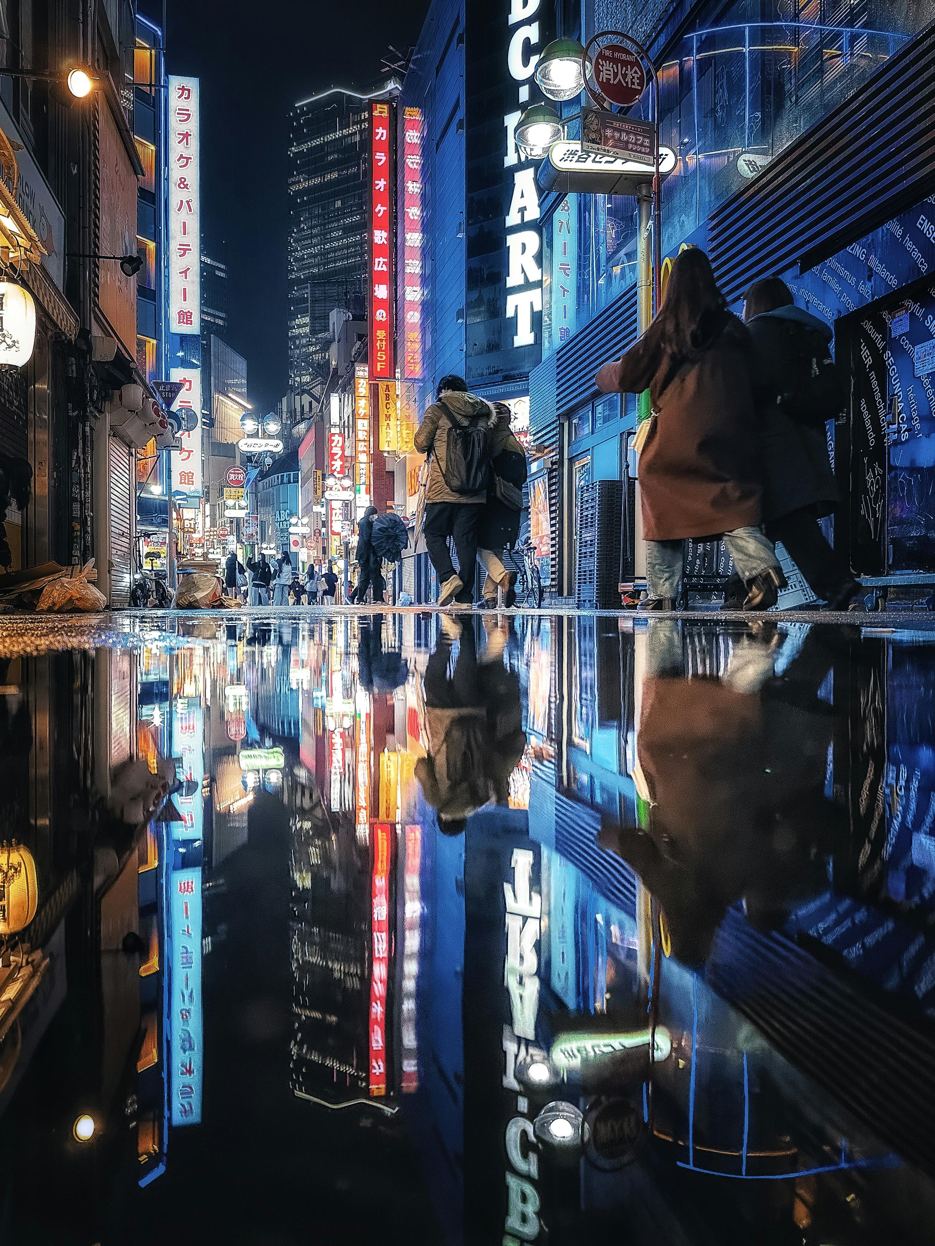 Vibrant nighttime reflection in Shibuya, Tokyo featuring colorful lights and urban atmosphere.