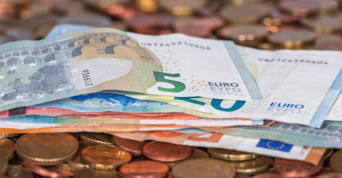 Stack of euro banknotes and scattered coins symbolizing wealth and finance.