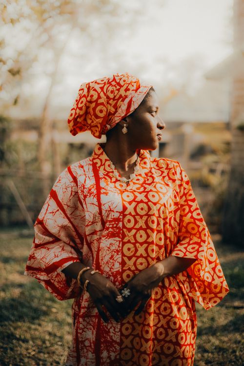 Free A woman in vibrant traditional clothing poses outdoors, exuding grace and culture. Stock Photo