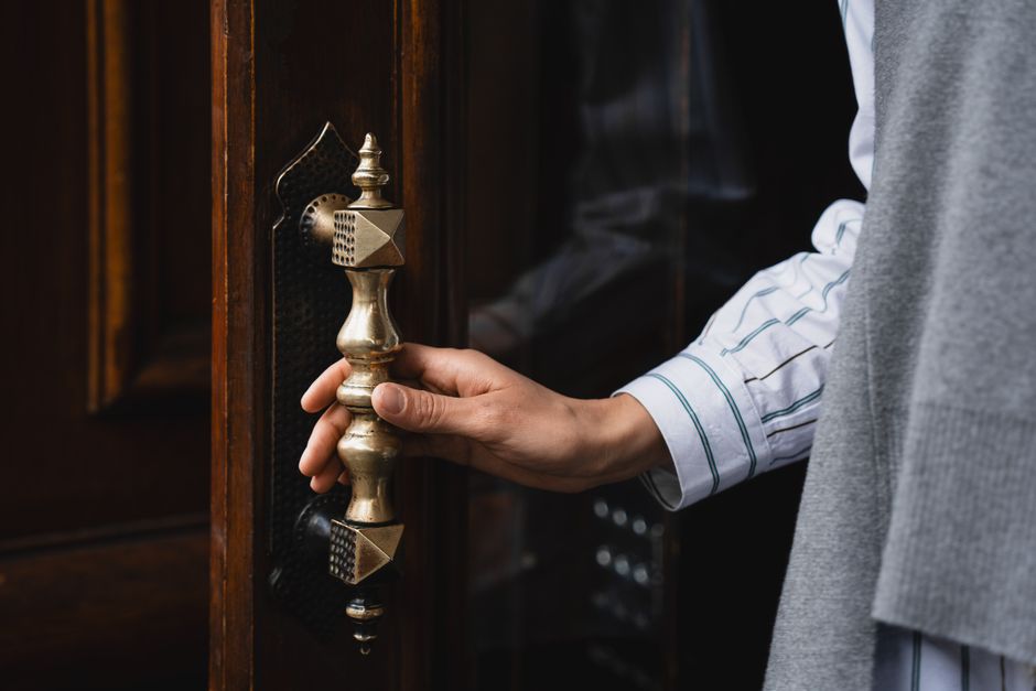 hand touching a door handle hand touching a door handle
