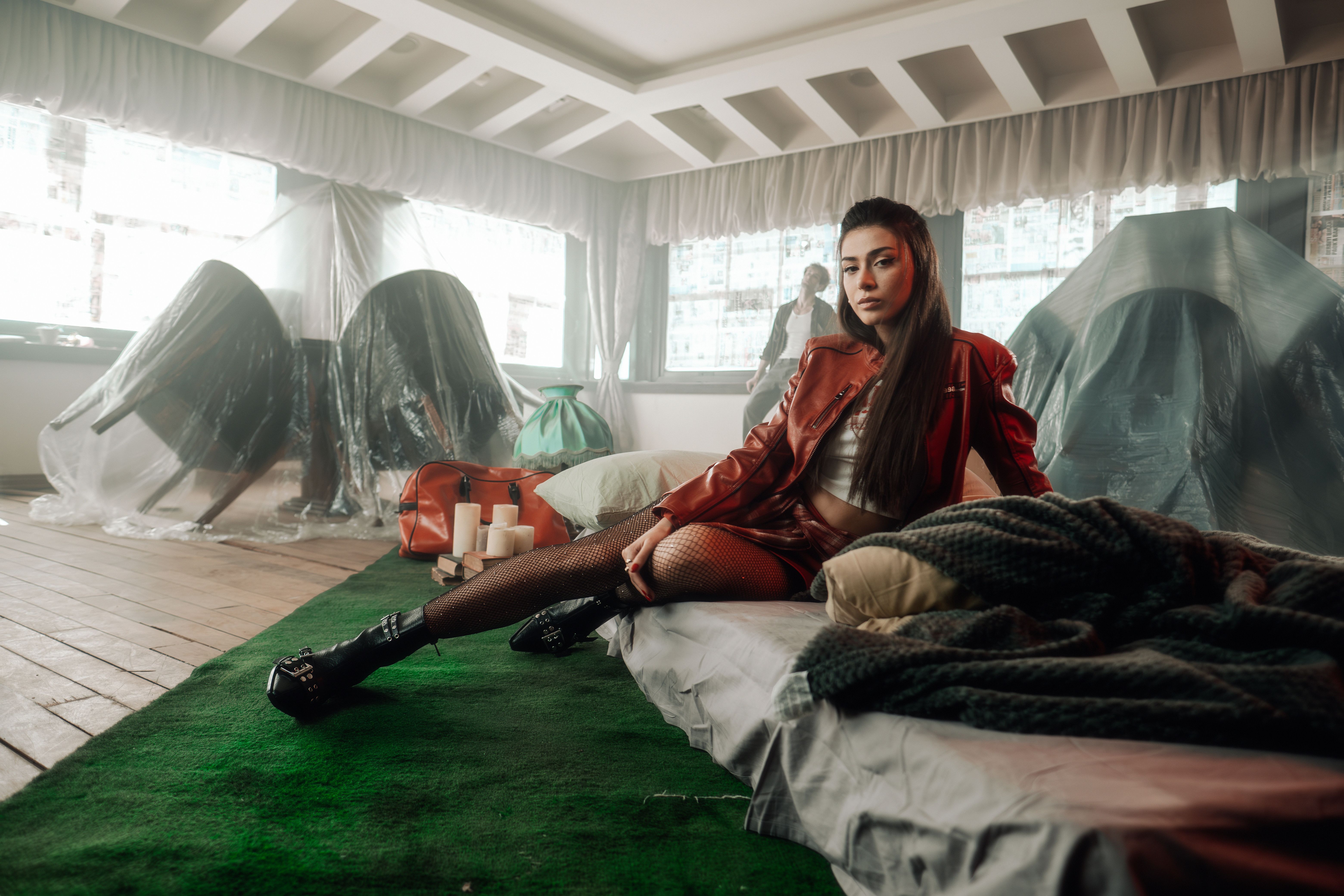 Una mujer elegante con un traje rojo posa en un ambiente interior contemporáneo con una decoración única.