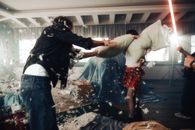 Energetic pillow fight with feathers flying indoors, capturing fun and chaos.