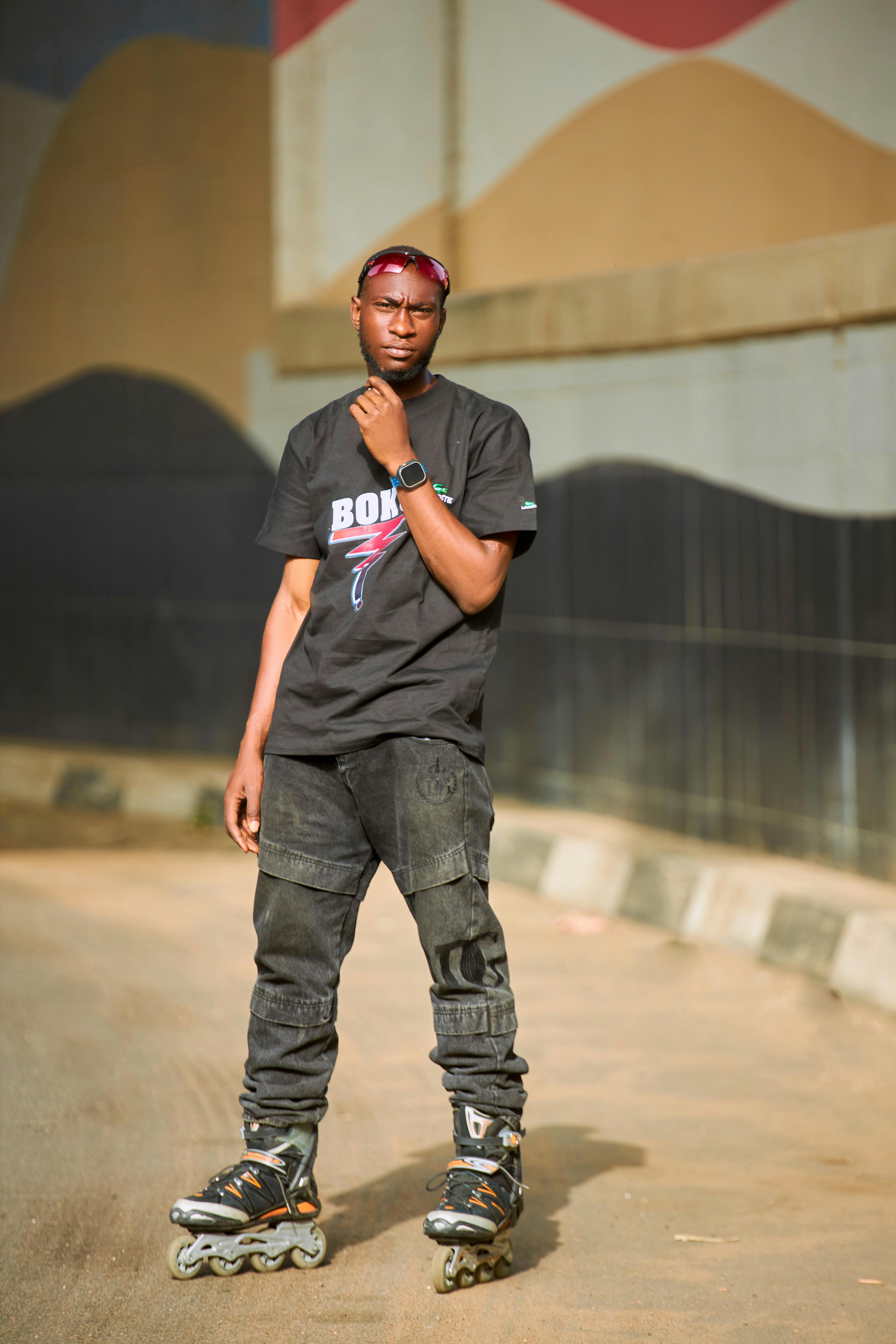 A young man on rollerblades in an urban setting, exuding confidence.