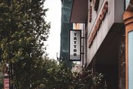 街景中城市建筑和绿化间的纹身店招牌
