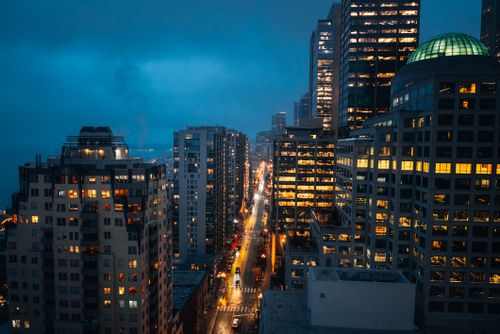Free Atmospheric cityscape of downtown Seattle at night with vibrant streetlights and skyscrapers. Stock Photo