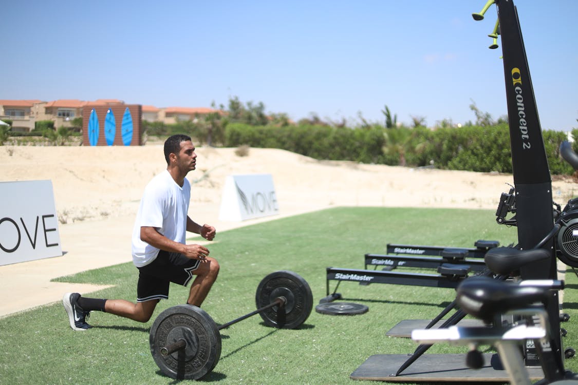 Athlete lifting weights on durable artificial turf in a CrossFit-style gym.