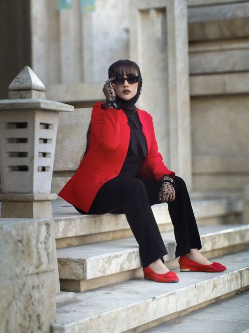 Free Stylish woman in red jacket and sunglasses posing confidently outdoors. Stock Photo