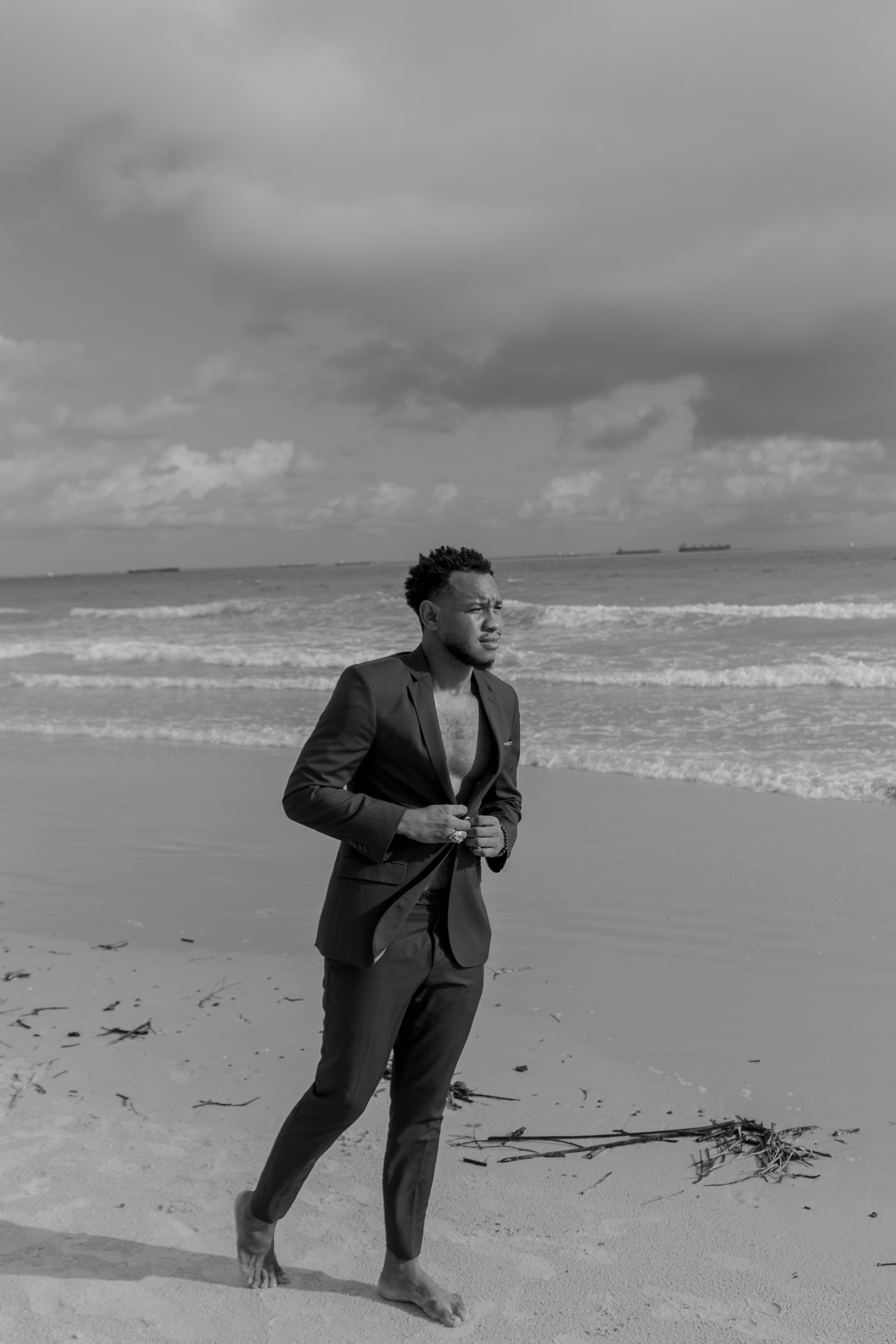 Hombre de traje en la playa frente al mar
