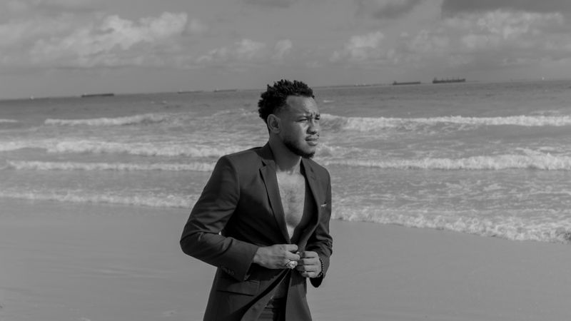 Hombre de traje en la playa frente al mar