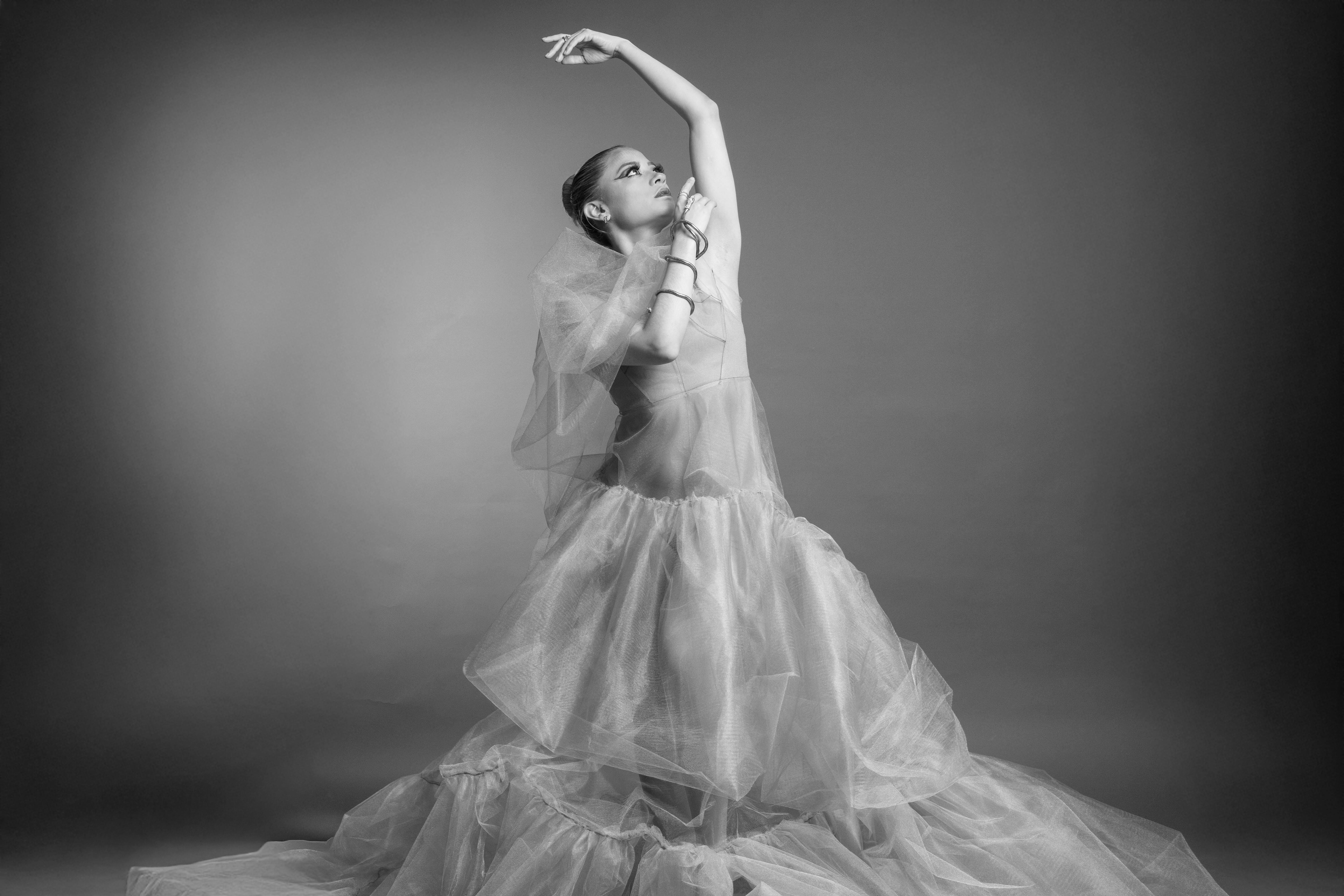 Black and white photo of a ballet dancer posing gracefully in a flowing dress.