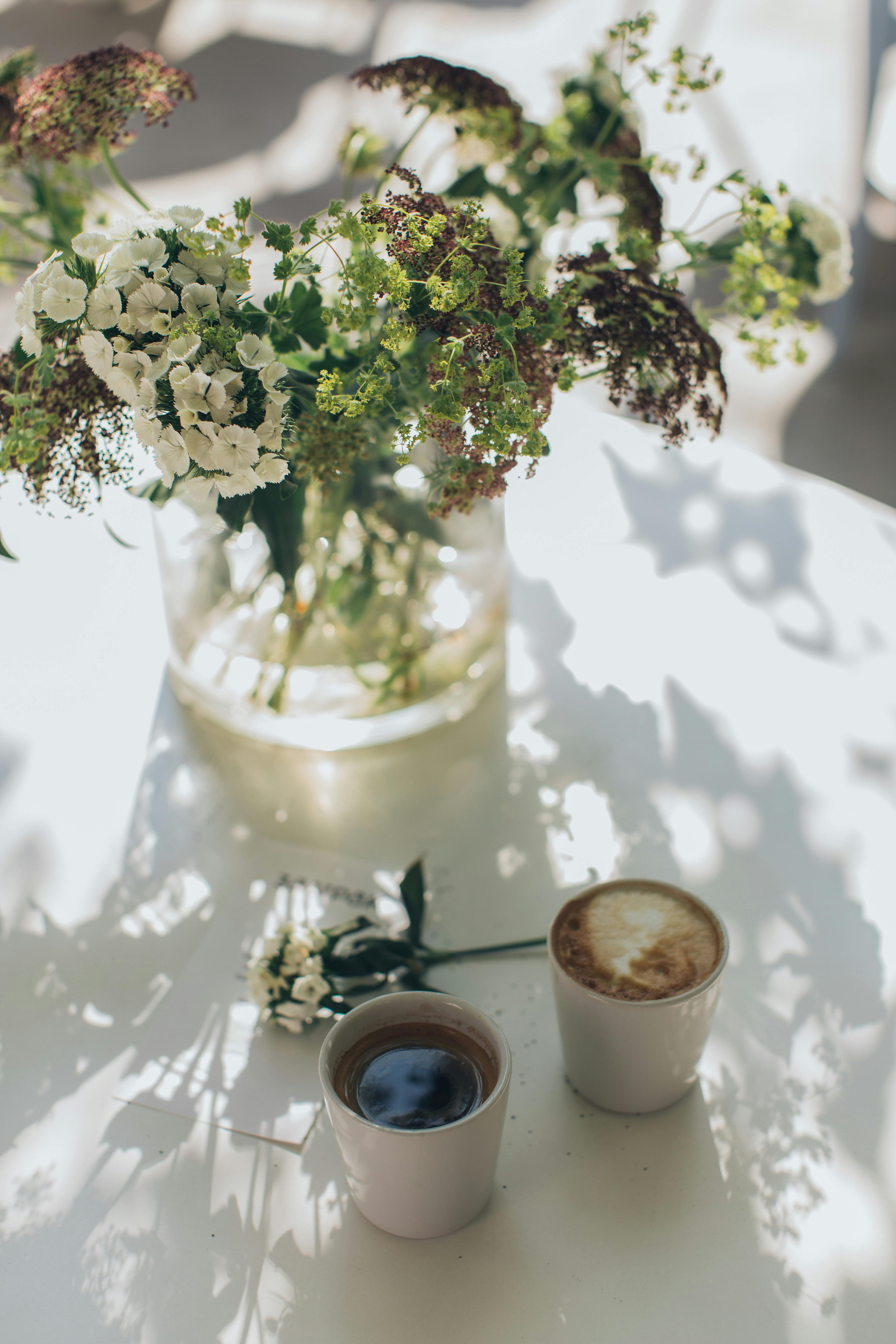 Photo Of Coffee Beside Vase · Free Stock Photo