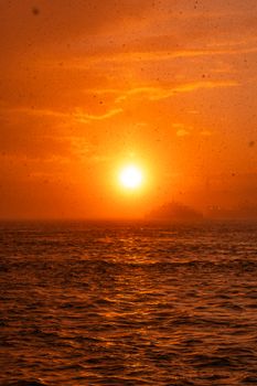 Stunning golden sunset over the ocean with gentle waves and a warm glow.