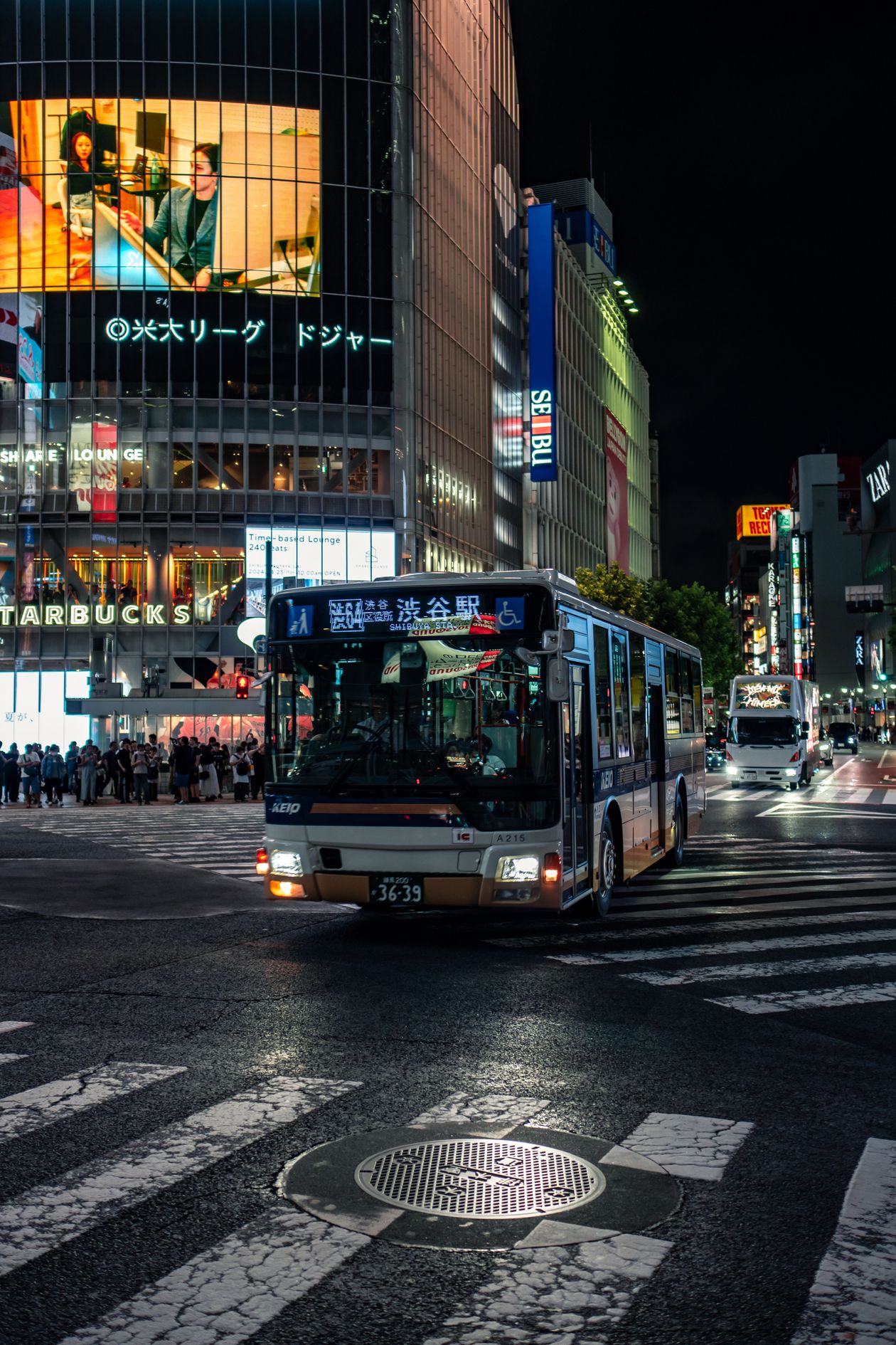 Busy nighttime scene at Shibuya Crossing in Tokyo with illuminated buildings