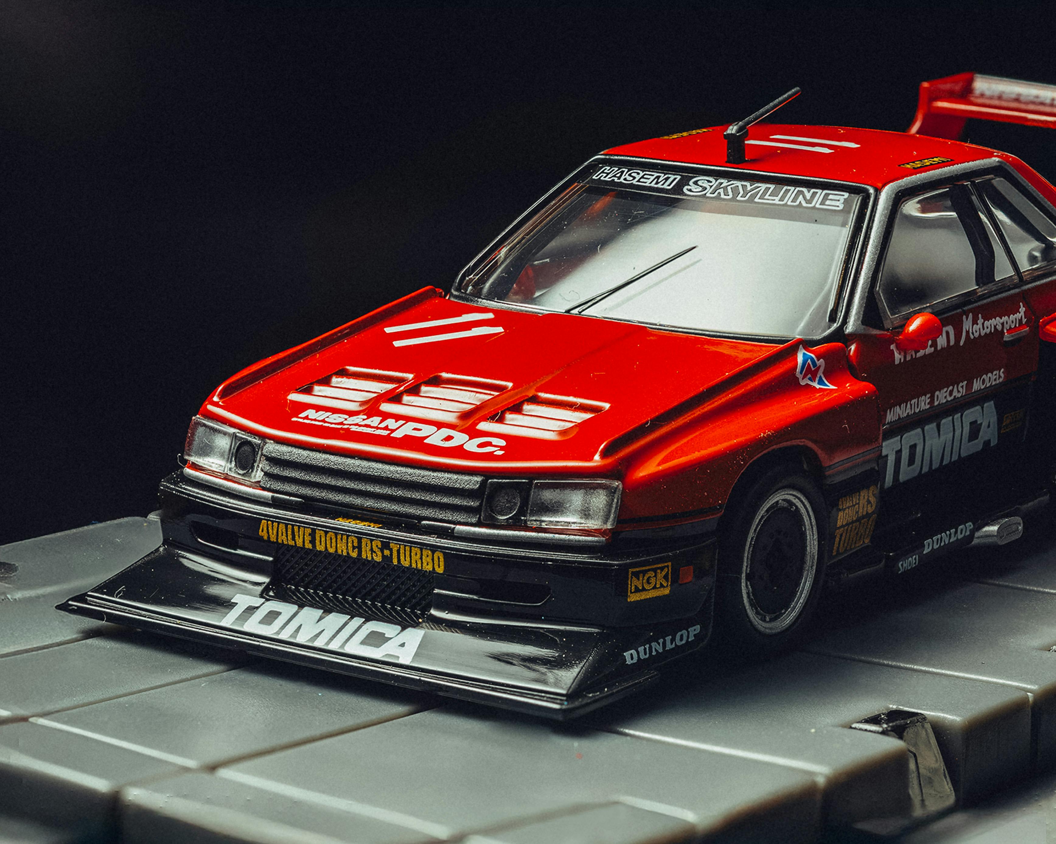 Gratis Nærbillede af en rød model Nissan Skyline-bil med detaljerede markeringer, ideel til bilentusiaster. Lagerfoto