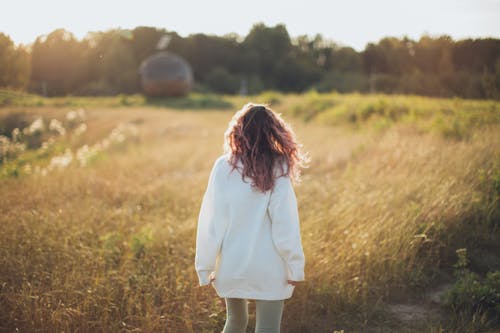 Woman Standing While Wearing White Jacket on Field