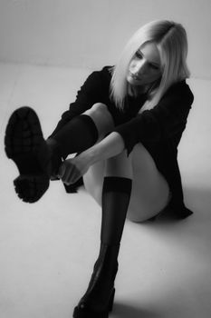 Elegant black and white portrait of a woman in fashion attire, highlighting style and attitude.