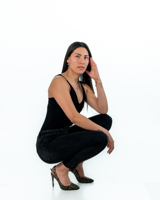 Portrait of a female model striking a pose showcasing style and elegance in a minimalist setting.