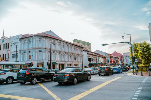 Free Busy street intersection with traffic and historic shophouses in downtown Singapore during the day. Stock Photo
