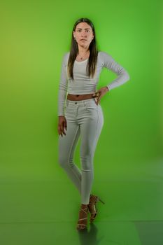 Portrait of a woman in white outfit against a vibrant green background