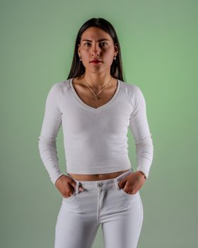 Portrait of a confident woman in white attire against a green backdrop.