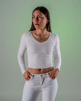 Stylish portrait of a woman in white with a green background conveying elegance and empowerment.