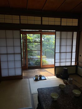 A serene traditional Japanese tea room with view of the garden through sliding doors.