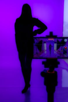A silhouette of a woman posing against a vibrant purple background, captured creatively with a smartphone.