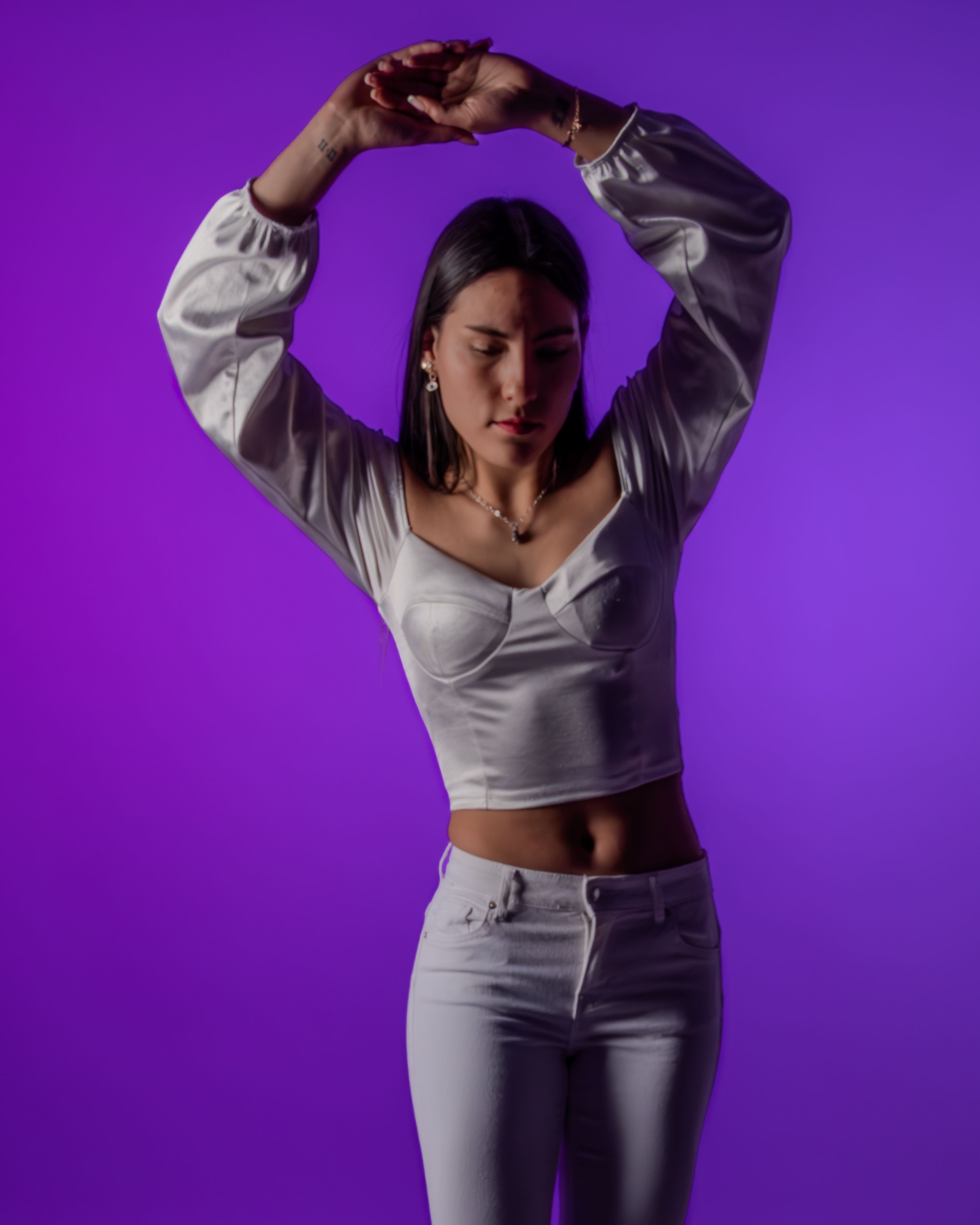 Elegant Woman Posing Against Purple Background · Free Stock Photo