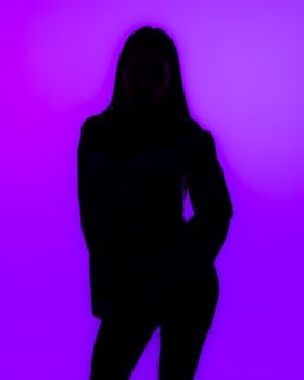Silhouette of a woman in front of a vibrant purple background, depicting mystery and creativity.