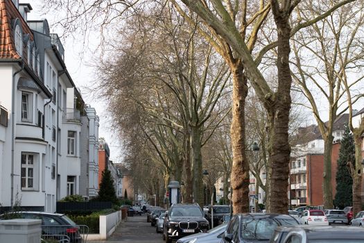 Picturesque residential street in Düsseldorf, Germany showcasing elegant architecture and bare trees in early spring.