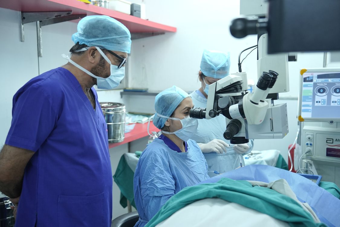 Free Surgeons performing eye surgery in a New Delhi hospital operating room. Stock Photo