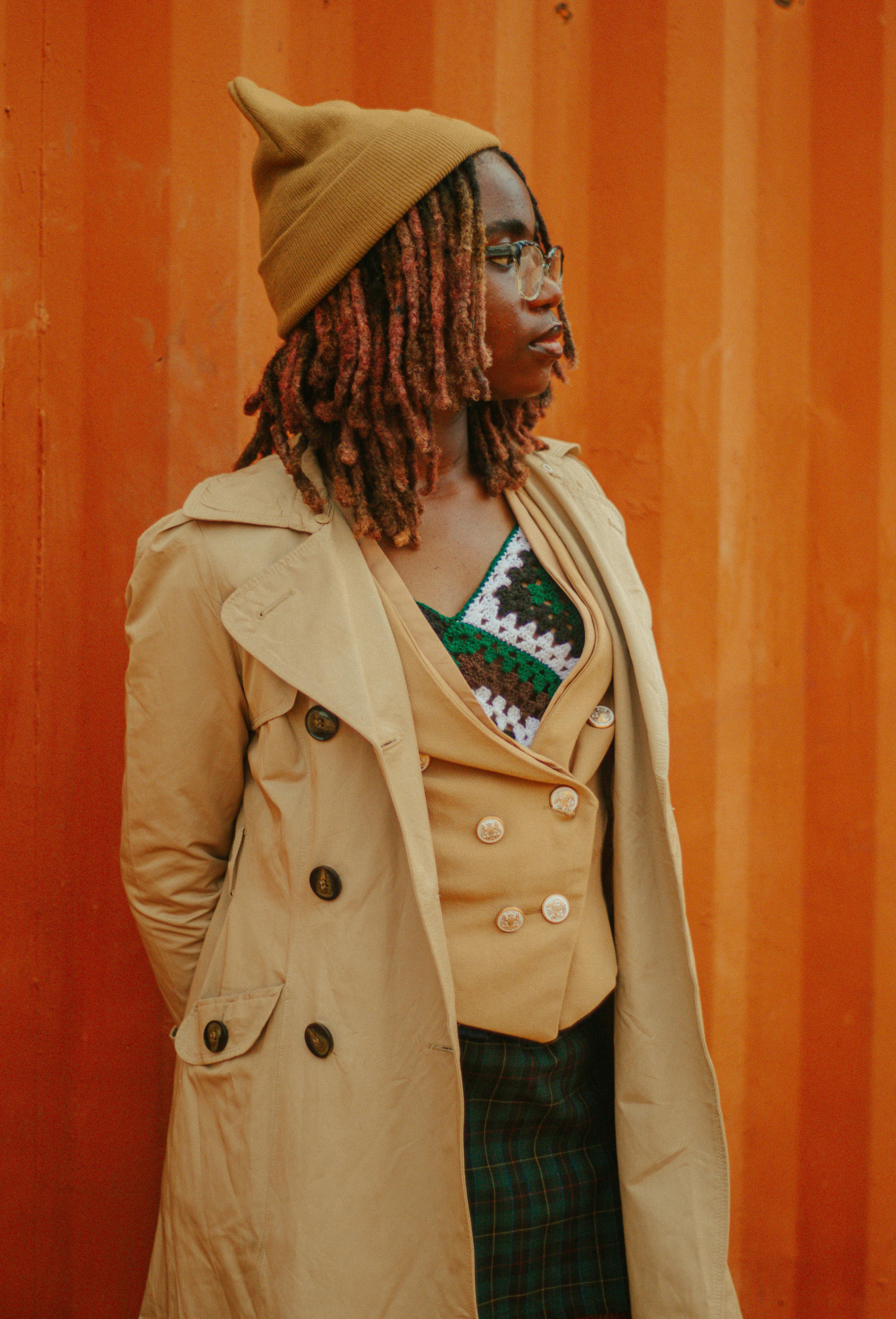 Portrait of a woman in a stylish trench coat with a warm autumn backdrop.