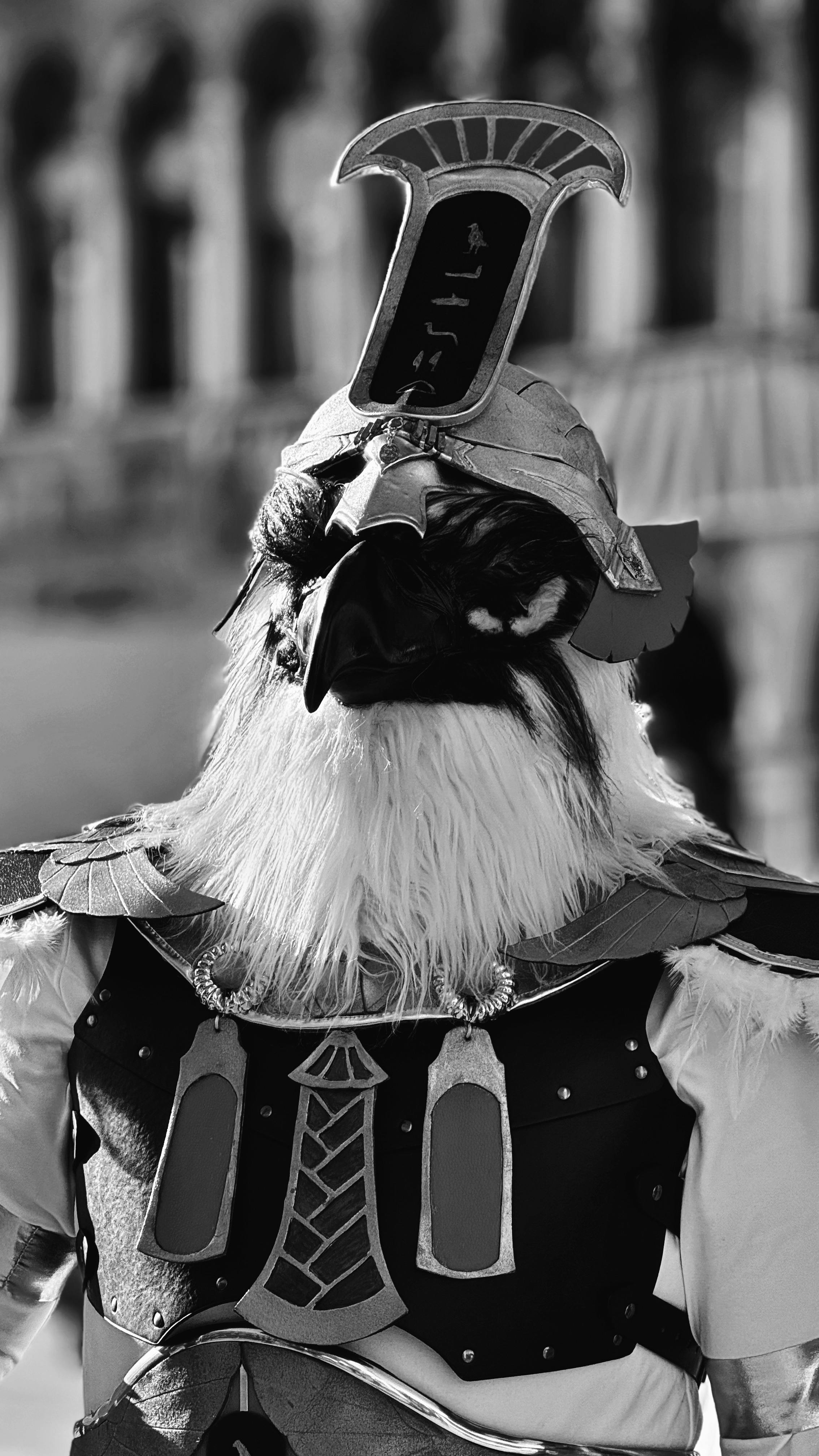 Artistic black and white portrait of a detailed bird costume at a festival.