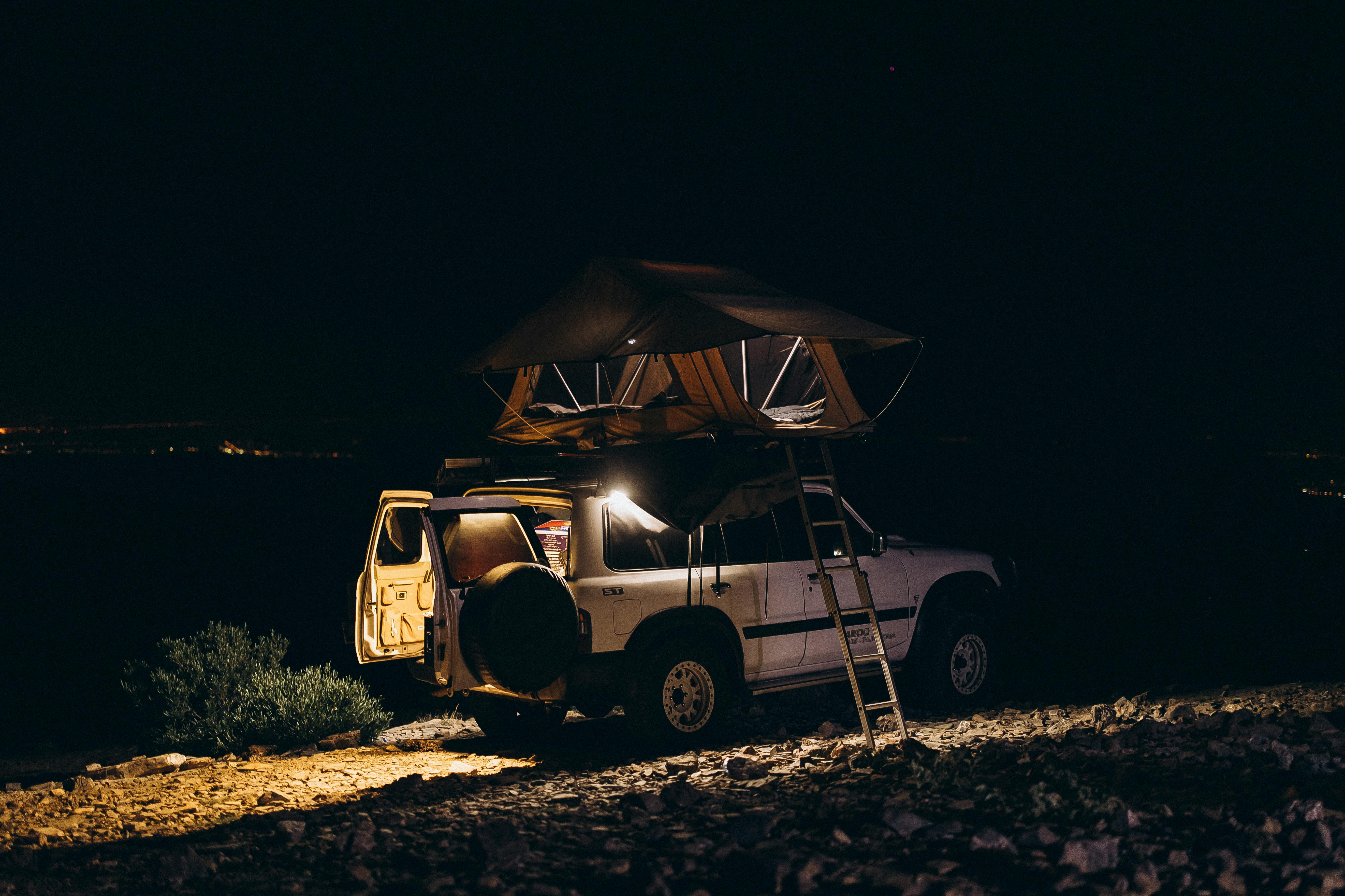 Explore 4x4 off-road camping under a vibrant starry night sky in the scenic landscapes of Oman.