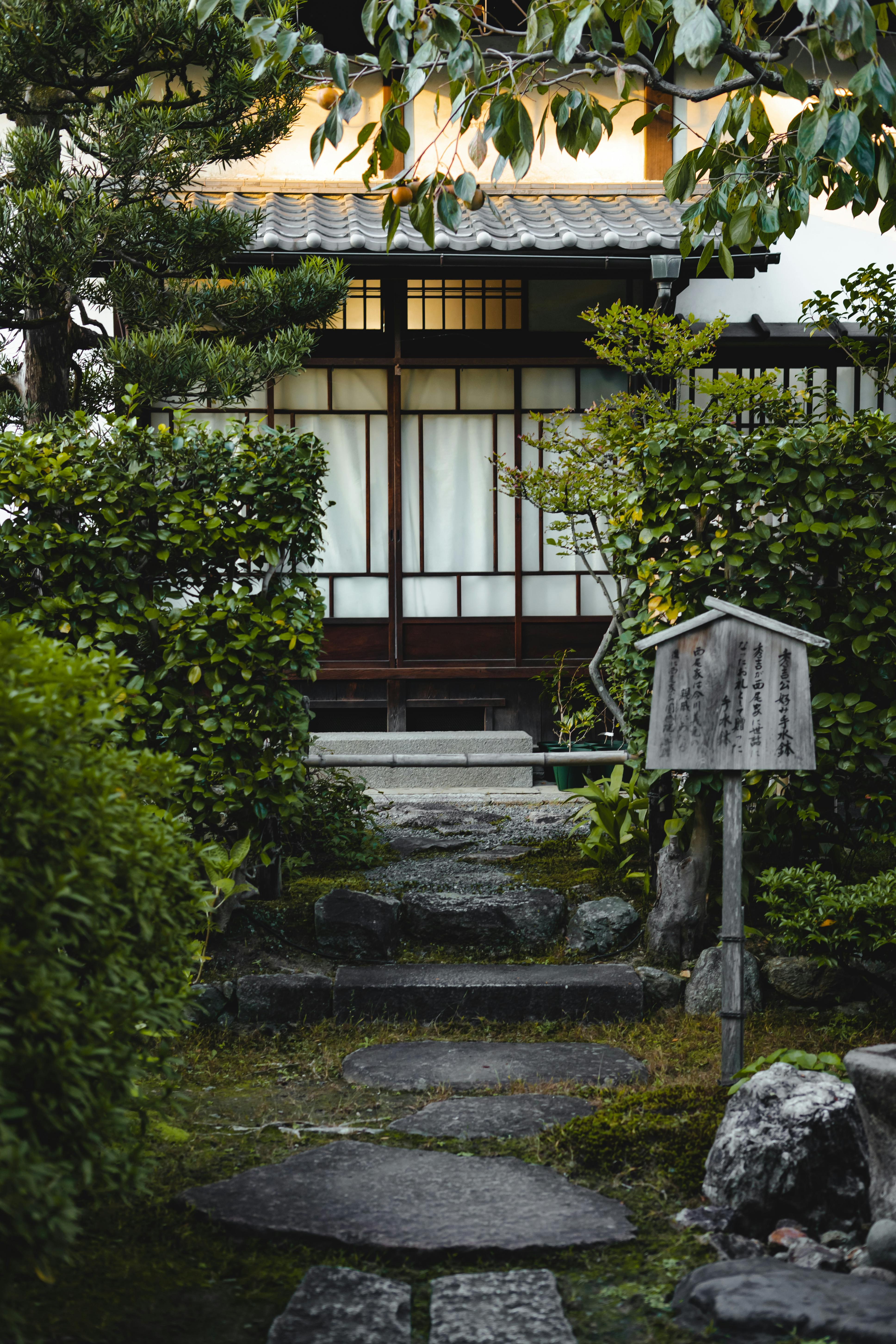 Peaceful Japanese garden scene with stone path leading to a traditional house.