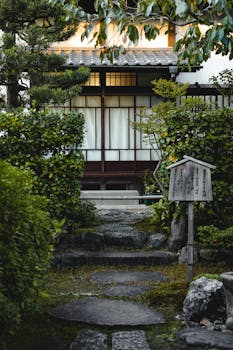 Peaceful Japanese garden scene with stone path leading to a traditional house.