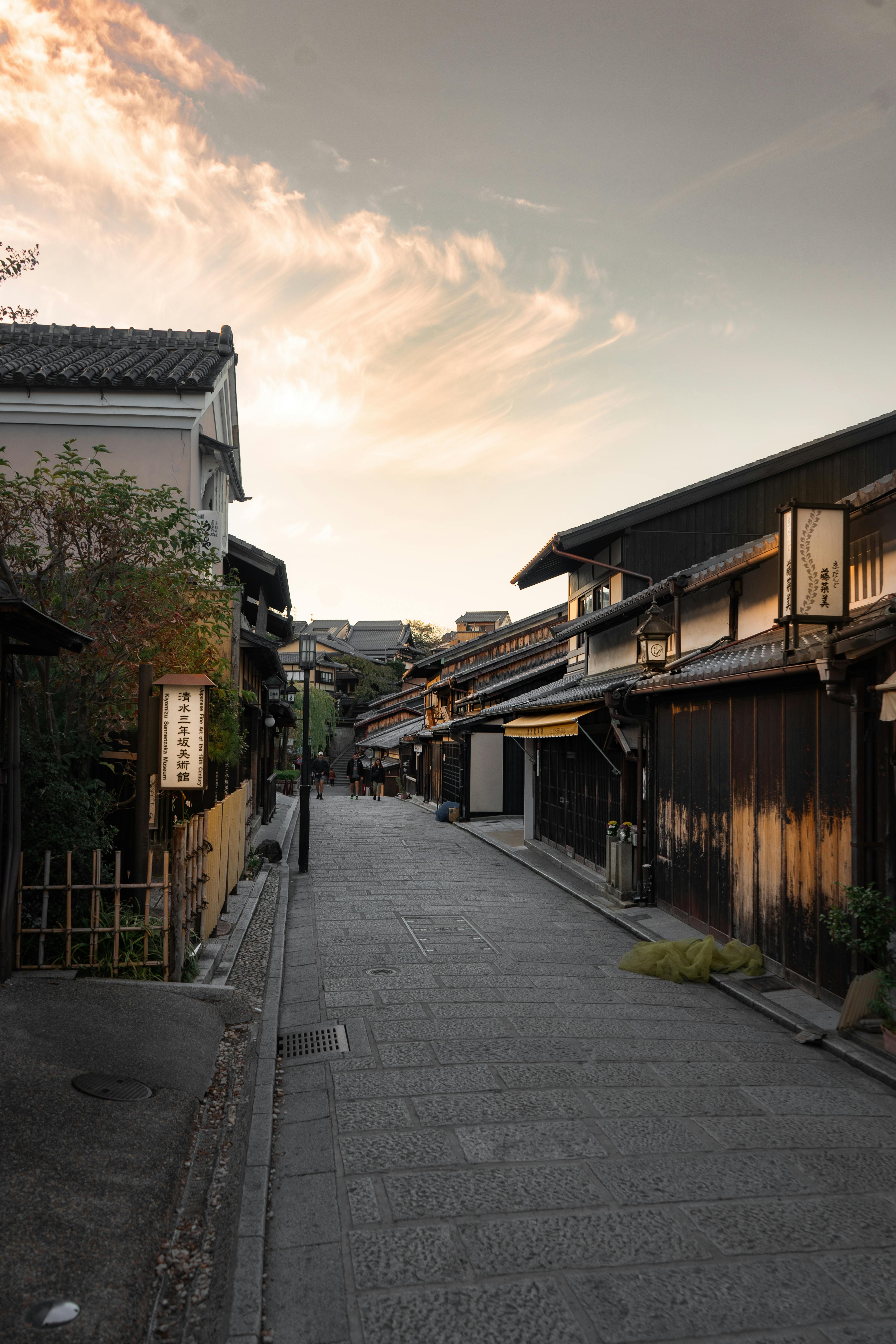 Quiet traditional Japanese street in Kyoto during sunset, showcasing wooden architecture.