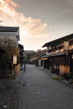 Quiet traditional Japanese street in Kyoto during sunset, showcasing wooden architecture.
