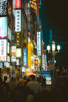 Bustling night scene of Shinjuku, Tokyo with neon lights and crowds.